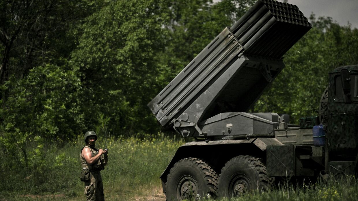 Украинский военный стоит рядом с РСЗО M270 MLRS