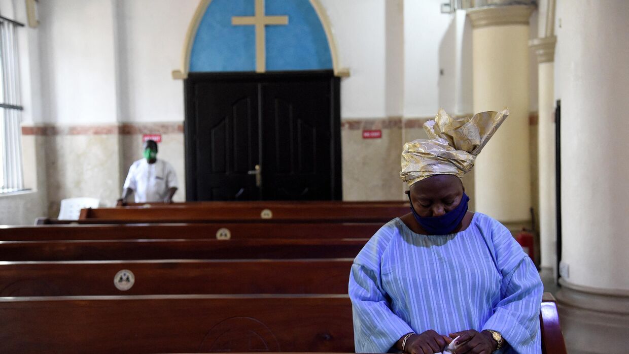 Женщина молится в соборе Святого Креста в Лагосе, Нигерия