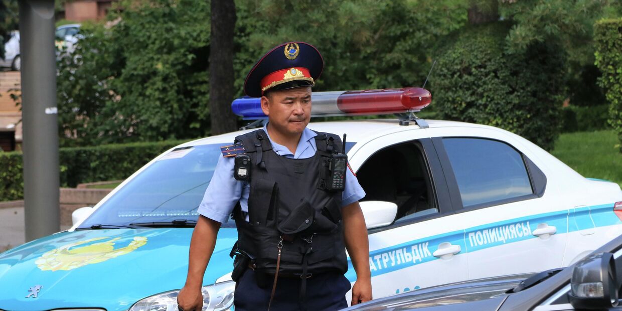 Сотрудник полиции около Алмалинского районного отдела внутренних дел (РОВД) в центре Алма-Аты