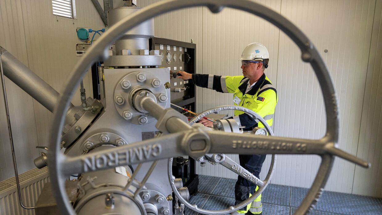 Сотрудник осматривает наземные сооружения хранилища природного газа в Бирванге, Германия