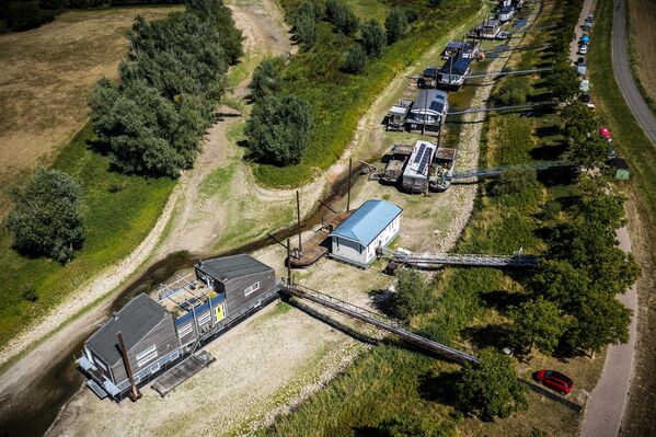 10 августа 2022 года. Дома на высохшем русле реки Ваал недалеко от Бенеден-Левена в Нидерландах