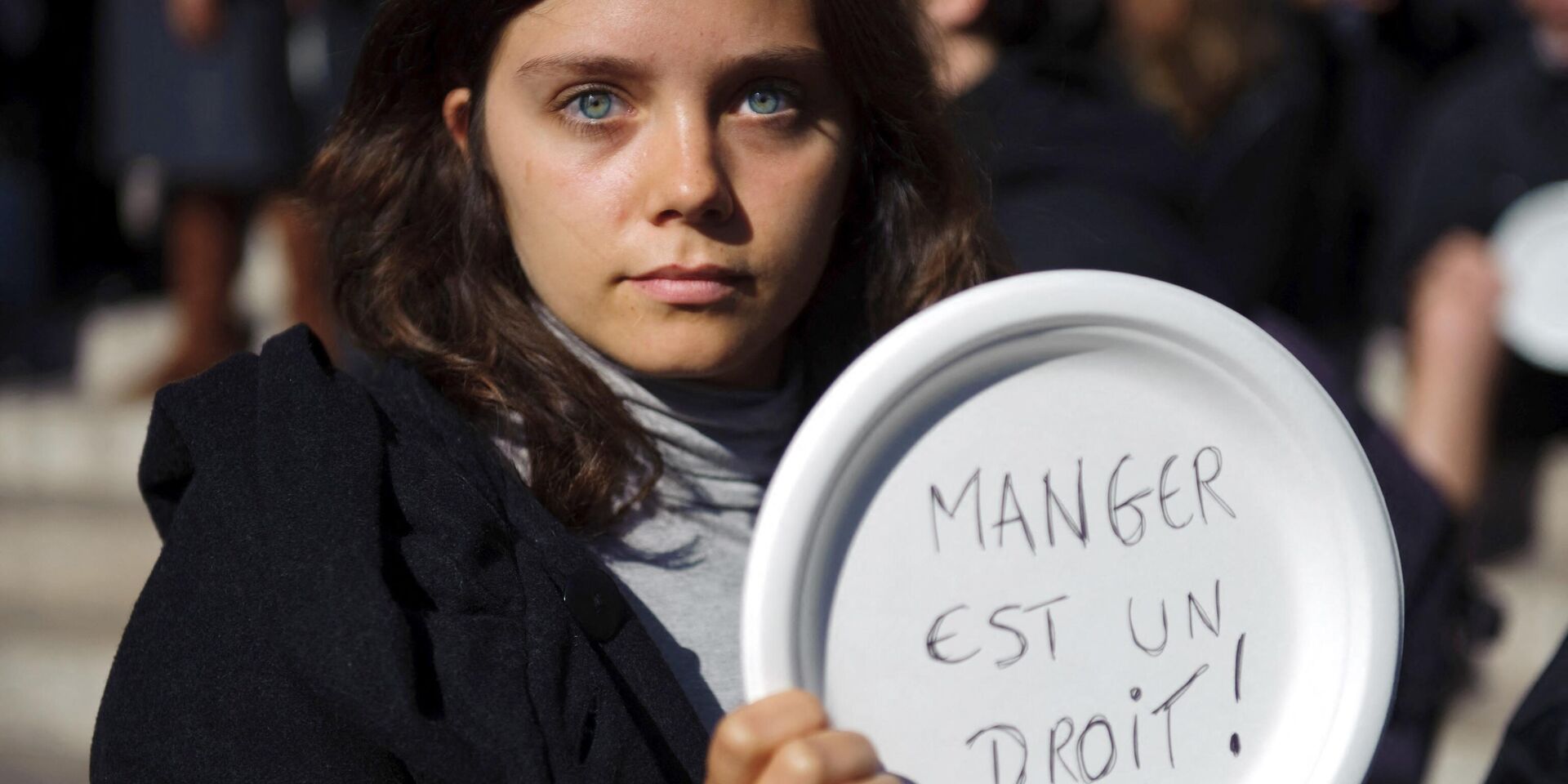 Девушка держит тарелку с лозунгом Питание - это право человека в Париже, Франция. Архивная фотография - ИноСМИ, 1920, 02.09.2022