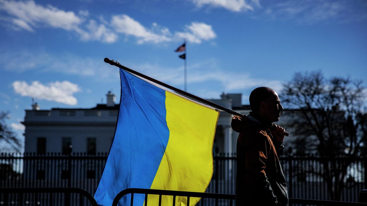 Мужчина с украинским флагом перед Белым домом в Вашингтоне, округ Колумбия. Архивная фотография