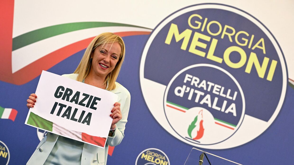 Лидер итальянской ультраправой партии Джорджия Мелони держит плакат с надписью Спасибо, Италия в Риме. 26 сентября 2022 года