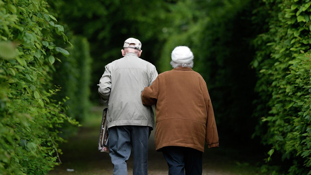 Пожилая пара прогуливается в парке в Гельзенкирхене, Германия