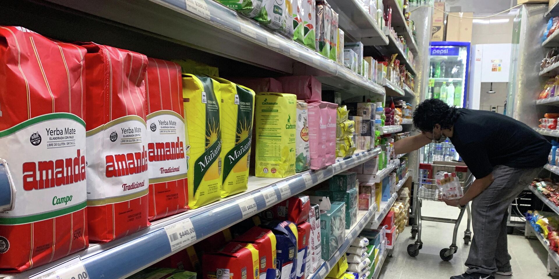 Мужчина раскладывает продукты в супермаркете в Буэнос-Айресе, 16 сентября 2022 года. - ИноСМИ, 1920, 05.10.2022