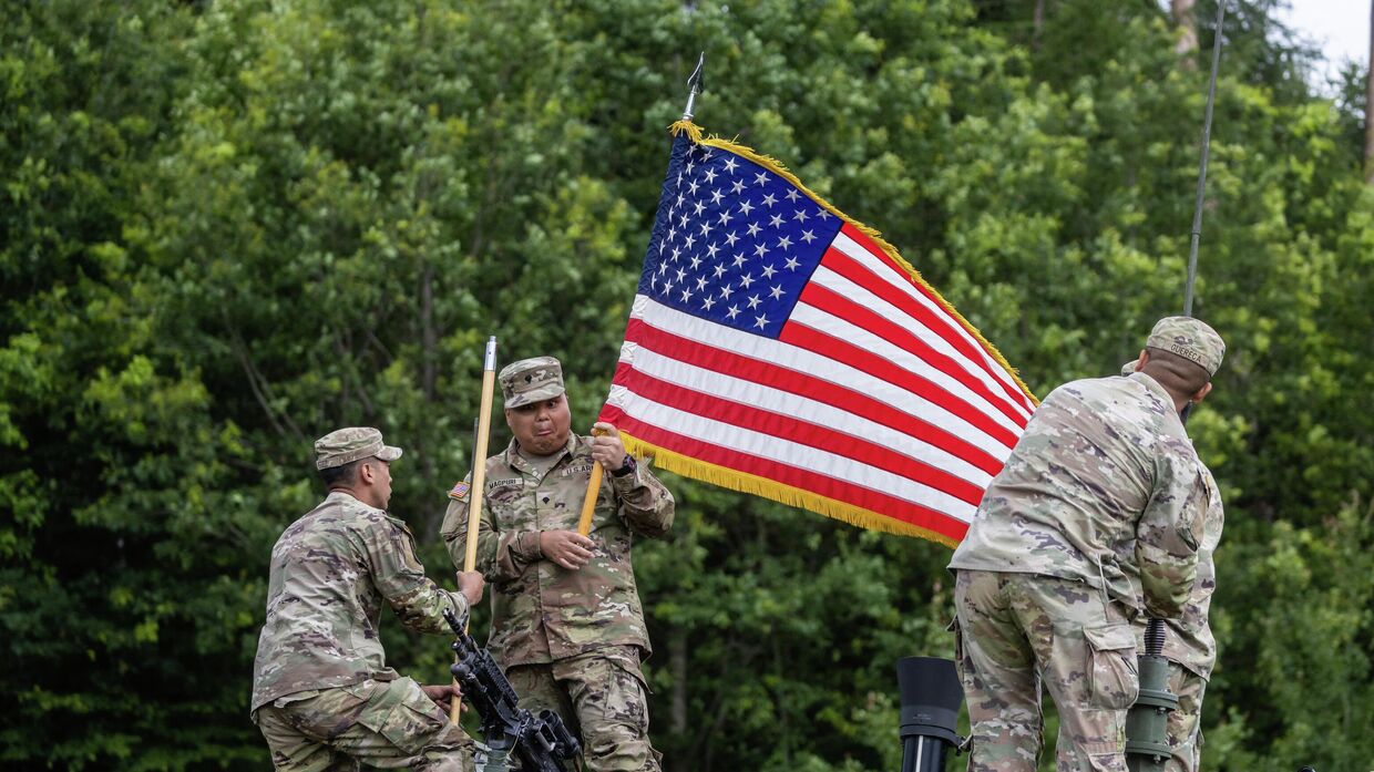 Американские солдаты устанавливают национальный флаг США в мобильном командном пункте НАТО близ деревни Шиплишки в Польше