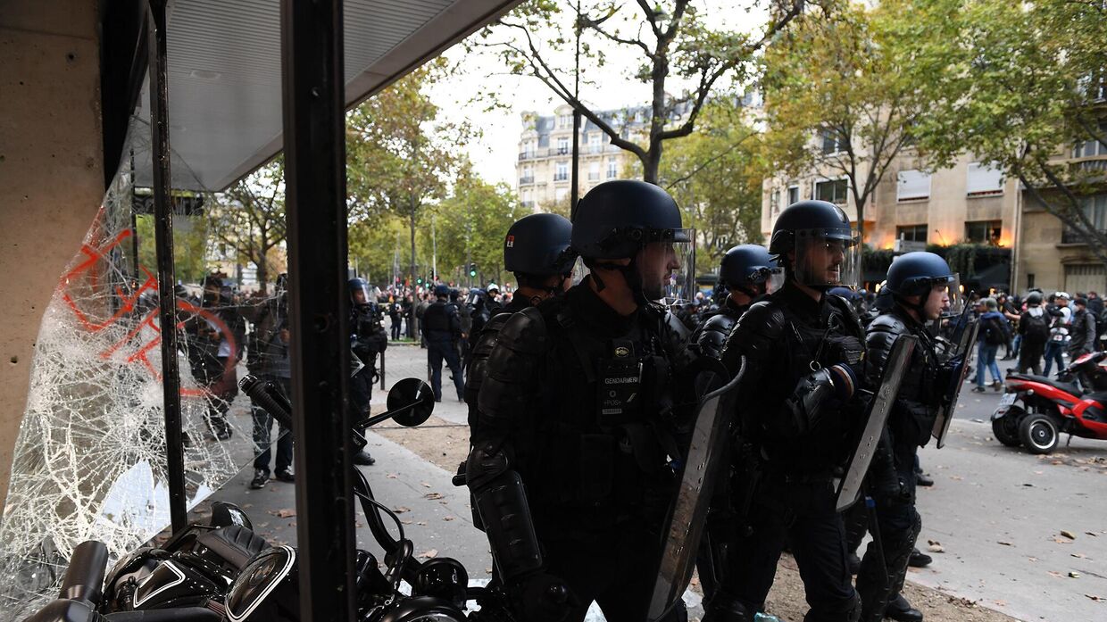 Сотрудники полиции во время столкновений с протестующими во время демонстрации в Париже, 18 октября 2022