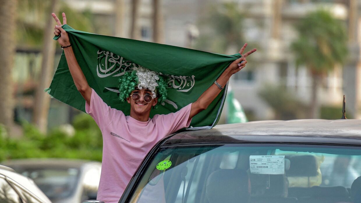 Болельщик сборной Саудовской Аравии празднует победу своей команды в Эр-Рияде