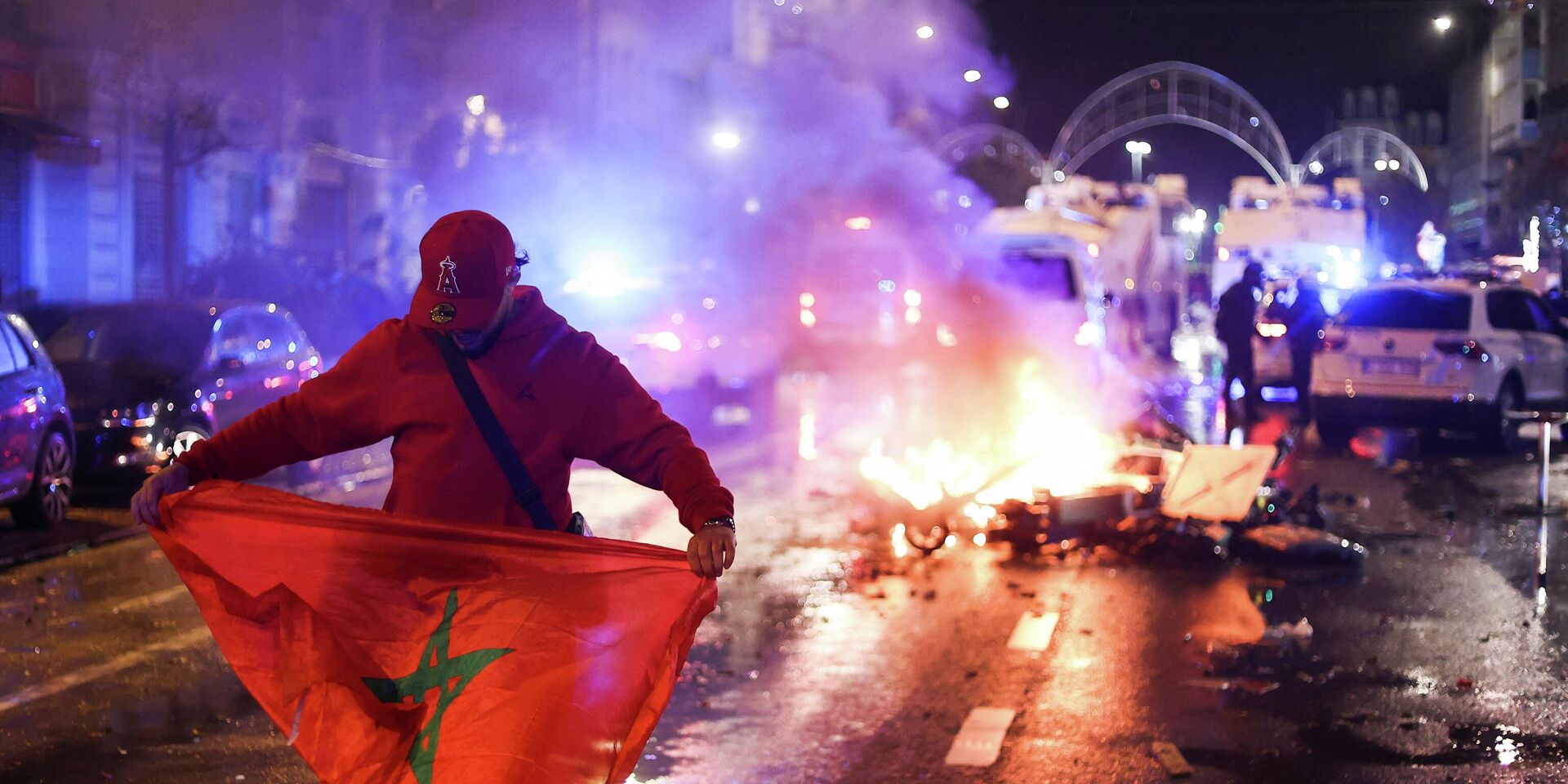 Болельщик держит марокканский флаг во время беспорядков в Брюсселе, Бельгия. 27 ноября 2022 года. - ИноСМИ, 1920, 28.11.2022