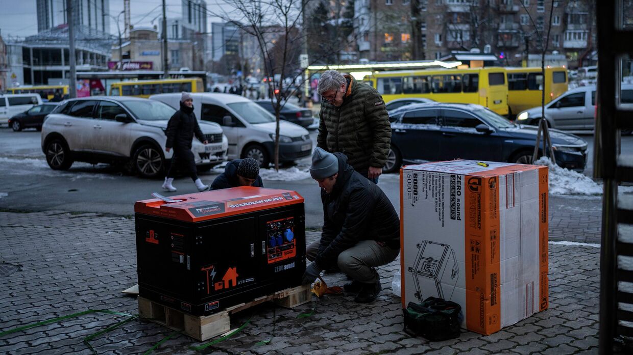 Украинцы устанавливают электрогенератор на одной из улиц Киева. 1 декабря 2022 года
