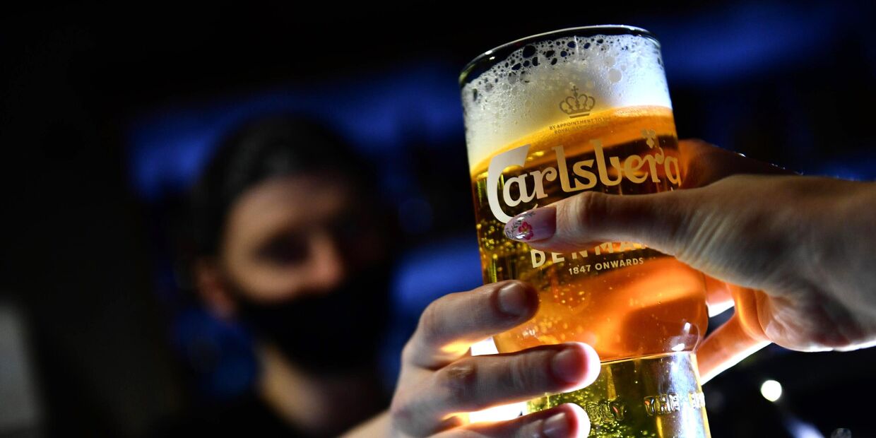 Бармен наполняет бокал пивом Carlsberg в баре ProRockBar в Екатеринбурге