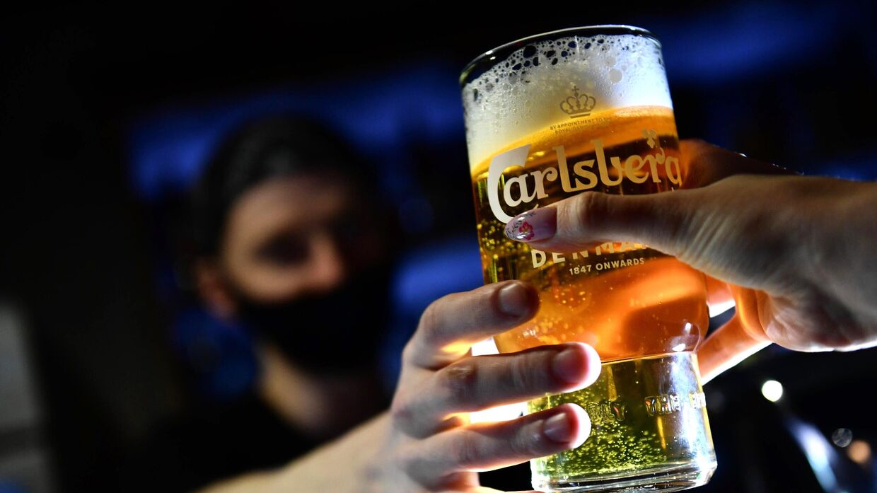 Бармен наполняет бокал пивом Carlsberg в баре ProRockBar в Екатеринбурге