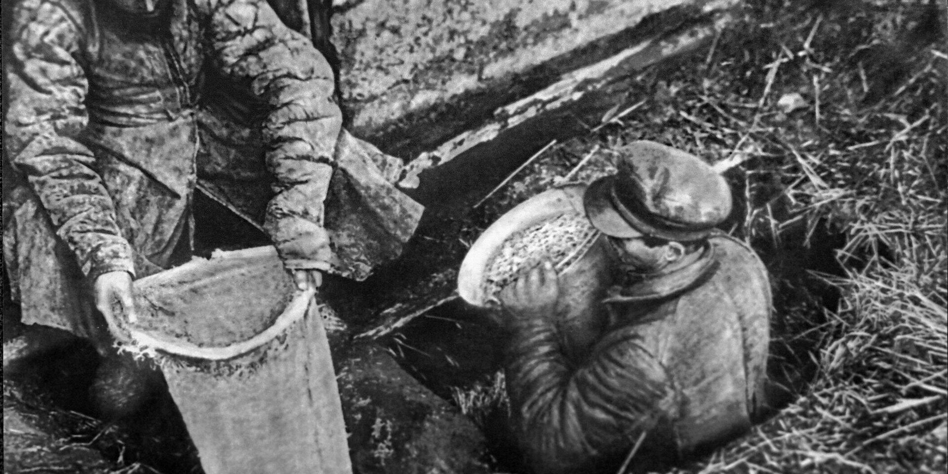Работники ОГПУ извлекают из ямы спрятанное зерно. 1932 год - ИноСМИ, 1920, 16.12.2022