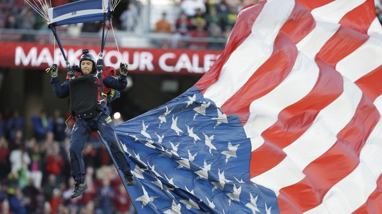 Парашютист с американским флагом перед футбольным матчем в Стэнфорде, Калифорния
