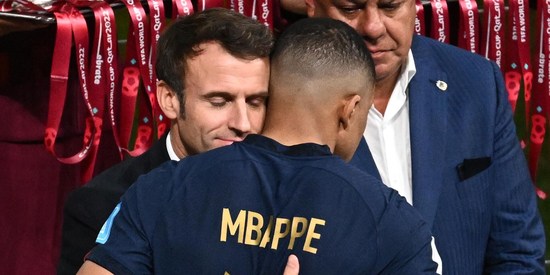 Президент Франции Эммануэль Макрон обнимает форварда сборной Франции Килиана Мбаппе после матча в Катаре. 18 декабря 2022 года - ИноСМИ, 1920, 23.12.2022