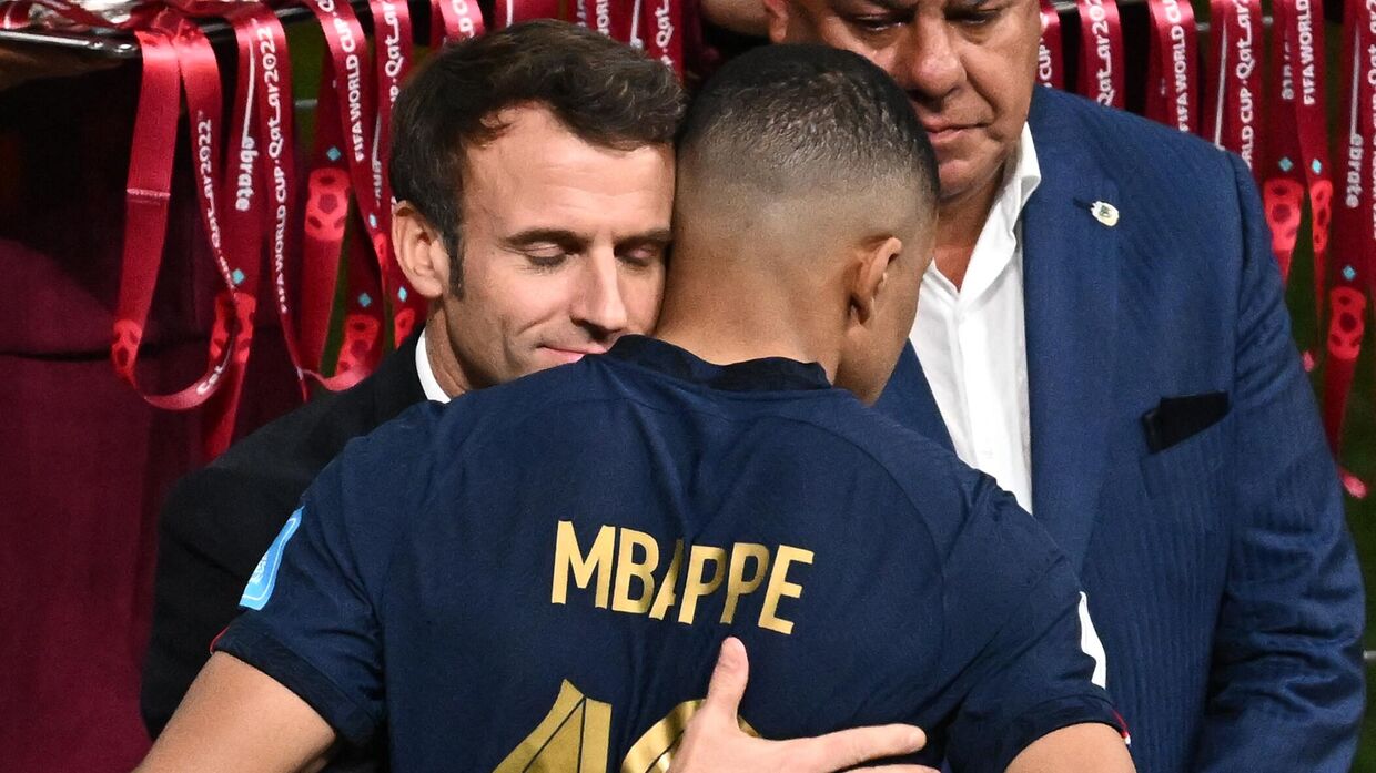 Президент Франции Эммануэль Макрон обнимает форварда сборной Франции Килиана Мбаппе после матча в Катаре. 18 декабря 2022 года