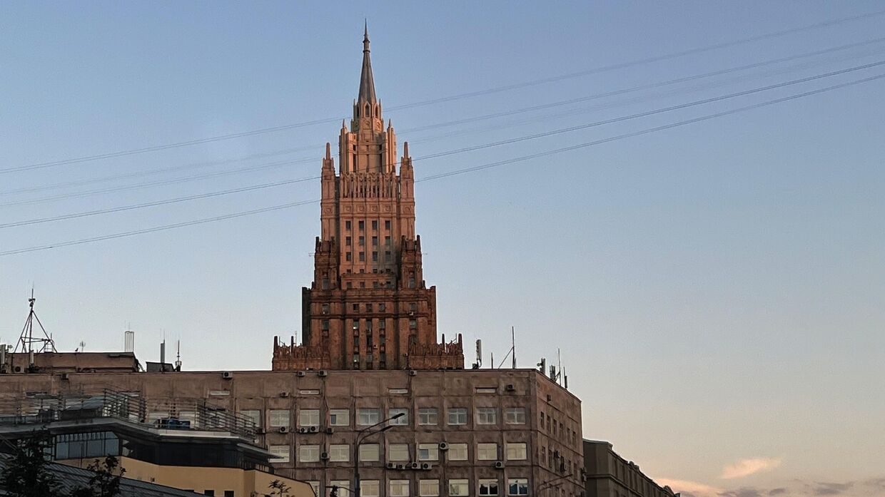 Шпиль здания Министерства иностранных дел РФ в городской застройке.