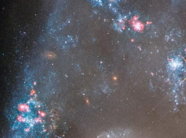 На этом снимке Arp 143 с телескопа Хаббла показаны новые звезды (обозначены синим цветом), образовавшиеся в результате выделения газа, нагревания и столкновений в пространстве между двумя основными скоплениями галактик. Звезды формировались по всей Вселенной в течение последних 13,6 миллиардов лет, и видимые на сегодняшний день образовывались неравномерно на протяжении всей космической истории.