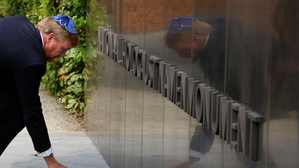 Король Нидерландов Виллем-Александр закладывает памятный камень во время открытия 19 сентября 2021 года нового памятника в историческом еврейском квартале Амстердама в честь 102 000 голландских жертв Холокоста.