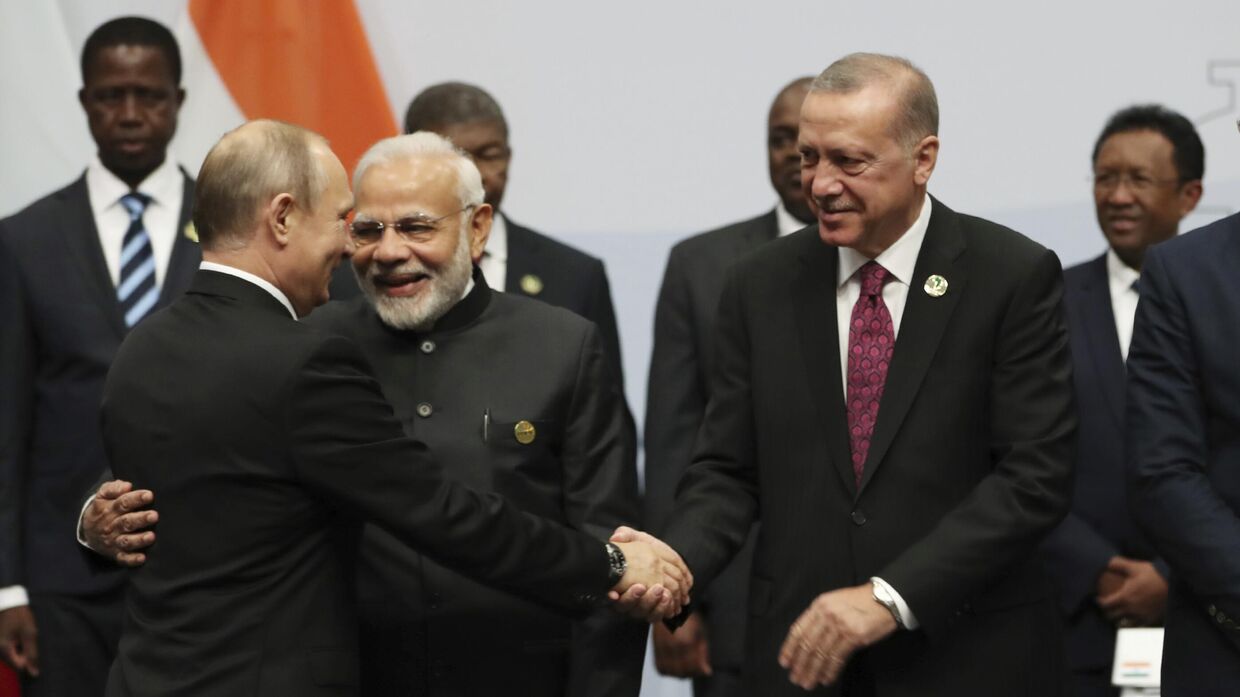 Президент Турции Реджеп Тайип Эрдоган обменивается рукопожатием с президентом России Владимиром Путиным перед тем, как они сфотографируются на саммите стран БРИКС в Йоханнесбурге, Южная Африка, 27 июля 2018 г. Премьер-министр Индии Нарендра Моди стоит между Путиным и Эрдоганом.