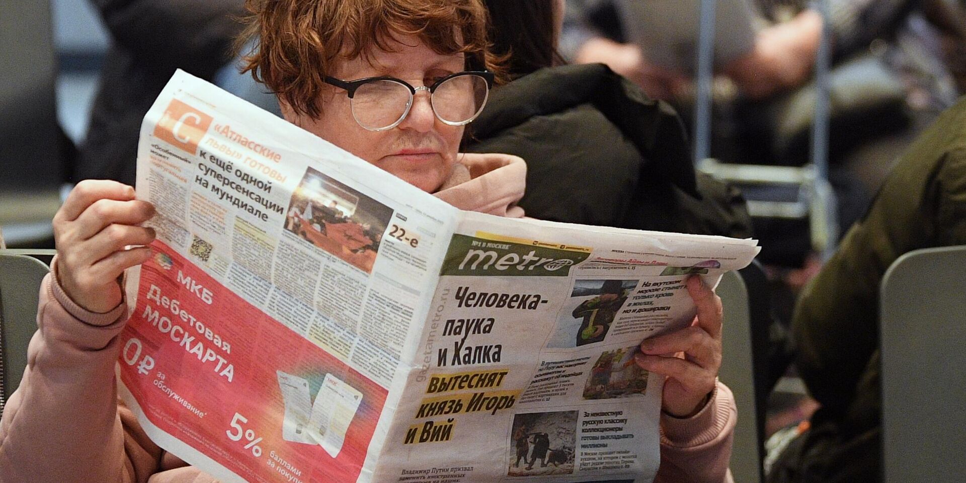 Пассажирка читает газету в зале ожидания на автовокзале Саларьево. - ИноСМИ, 1920, 25.06.2023
