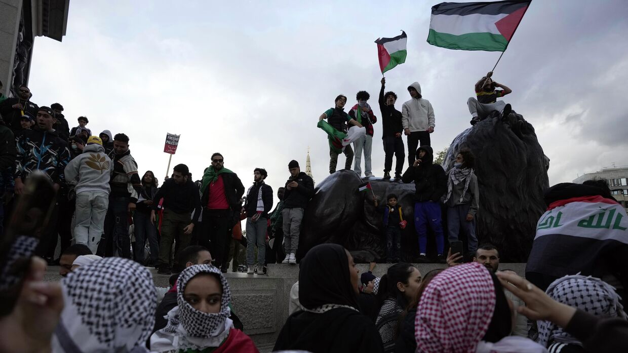 Протестующие держат флаги Палестины во время пропалестинской демонстрации в Лондоне. Суббота, 14 октября 2023 года