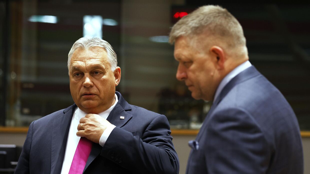 Премьер-министр Венгрии Виктор Орбан, слева, беседует с премьер-министром Словакии Робертом Фицо во время заседания круглого стола на саммите ЕС в Брюсселе. 26 октября 2023 года