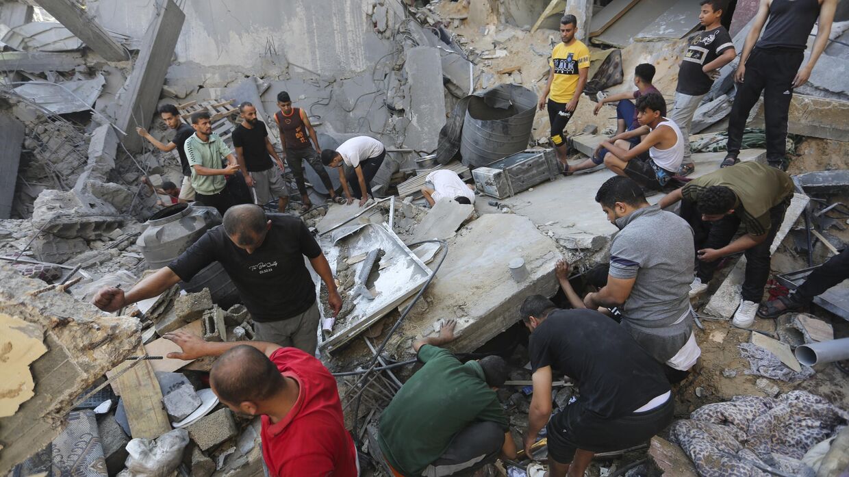Палестинцы ищут выживших после израильского удара в Рафахе, сектор Газа. 31 октября 2023 года