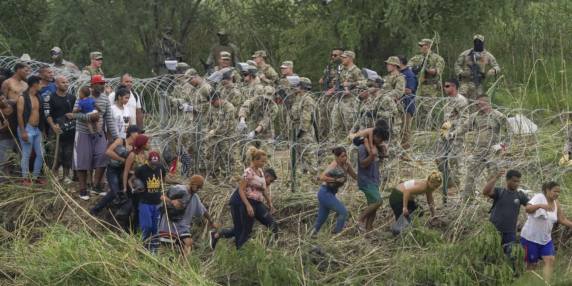 Национальные гвардейцы штата Техас укрепляют полосу колючей проволоки на берегу Рио-Гранде в то время, когда мигранты пытаются проникнуть в США. 11 мая 2023 года - ИноСМИ, 1920, 01.11.2023