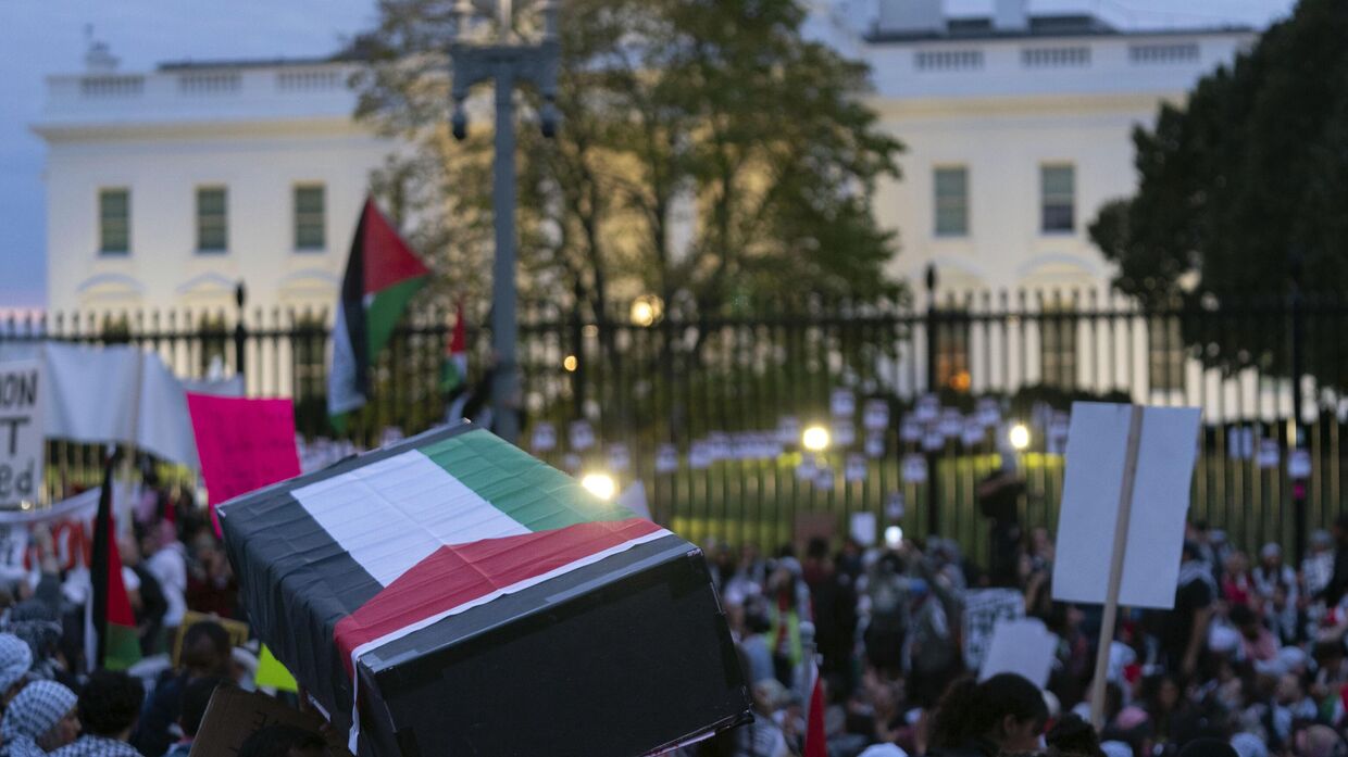 Антивоенные активисты несут макет гроба, накрытый палестинским флагом, перед Белым домом во время пропалестинской демонстрации с требованием прекращения огня в секторе Газа. Вашингтон, 4 ноября 2023 года