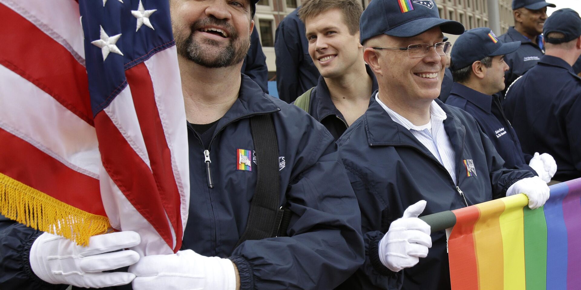 Мастер-сержант ВВС США в отставке Эрик Буллен (слева) держит американский флаг, а ветеран армии США Ян Райан (справа) - радужный флаг после шествия с группой ЛГБТ-военных на параде в День ветеранов в Бостоне. Архивная фотография - ИноСМИ, 1920, 23.11.2023