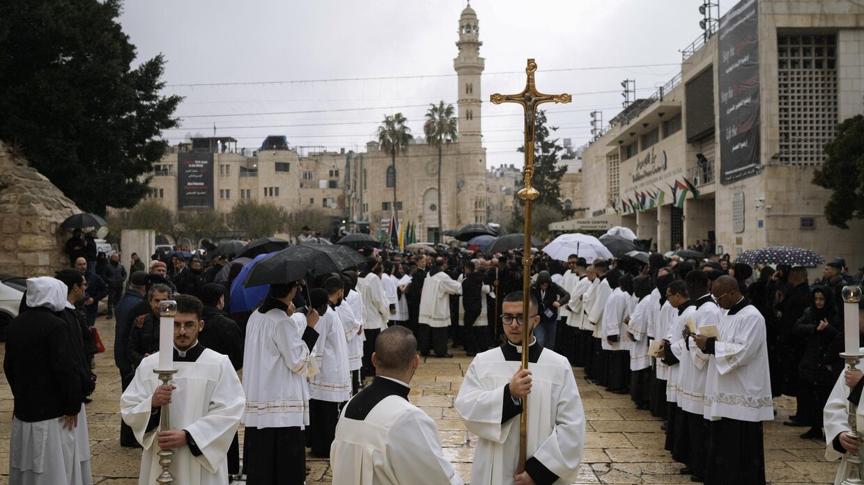 Католическое духовенство идет процессией к церкви Рождества Христова в канун Рождества в городе Вифлеем на Западном берегу реки Иордан, воскресенье, 24 декабря 2023 года.