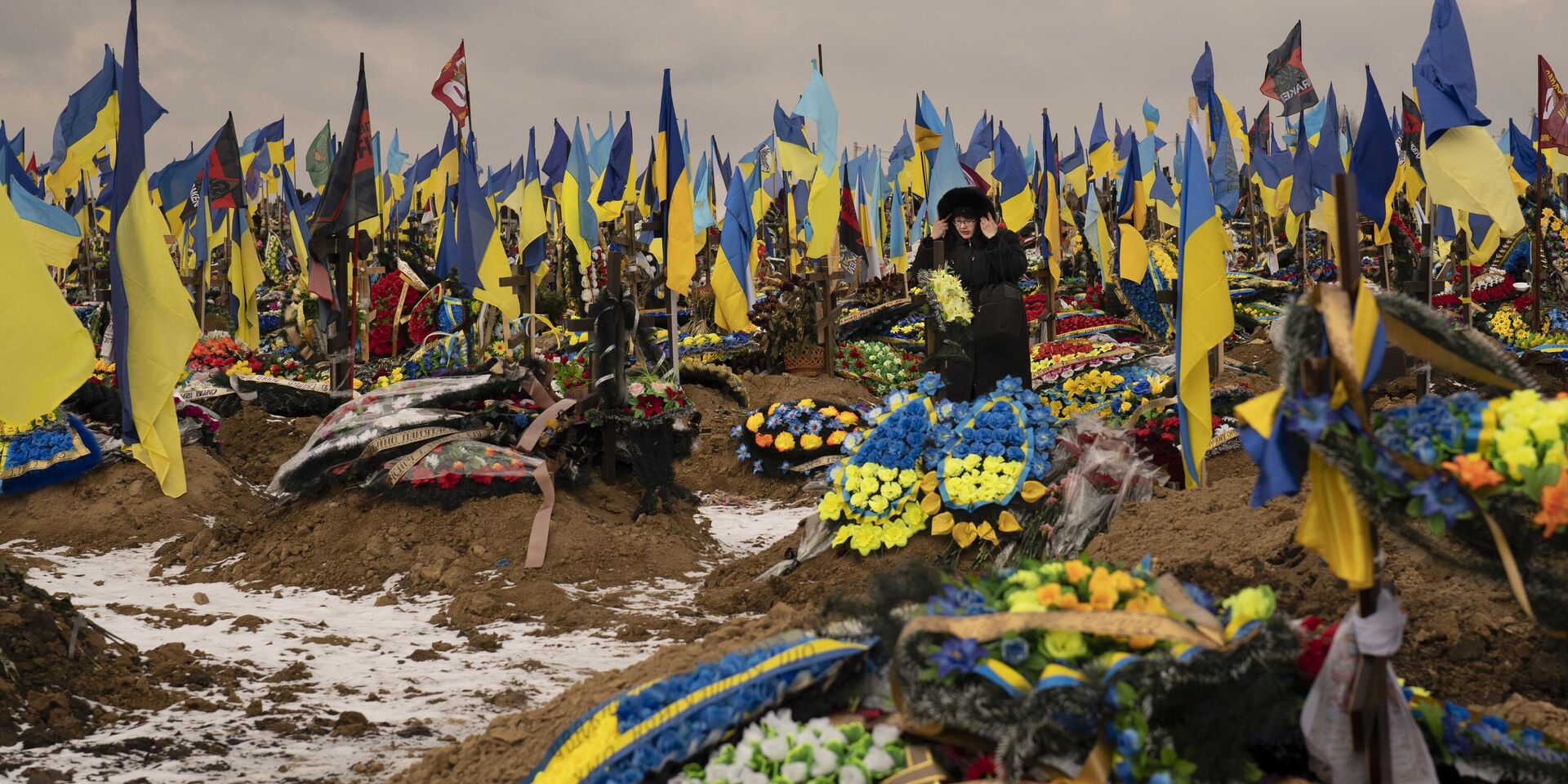 Женщина проходит между могилами солдат во время похорон Геннадия Ковшика, который был убит на передовой на востоке Украины - ИноСМИ, 1920, 13.03.2024