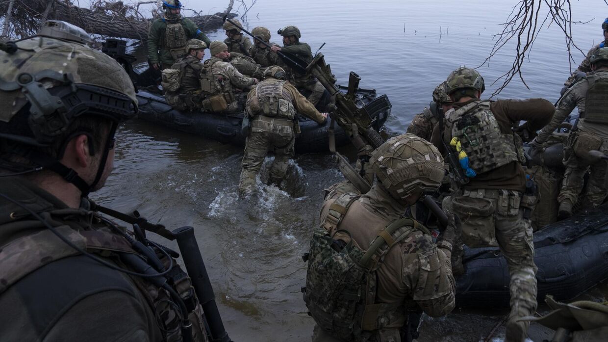 Украинские военнослужащие садятся в лодку на берегу Днепра близ Херсона, Украина