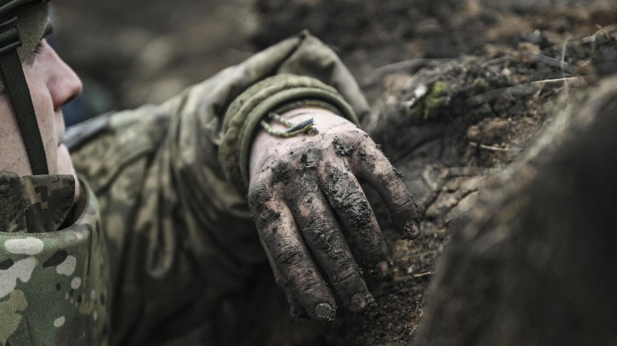 Украинский солдат укрывается в окопе близ Артемовска в Донбассе 8 марта 2023 года