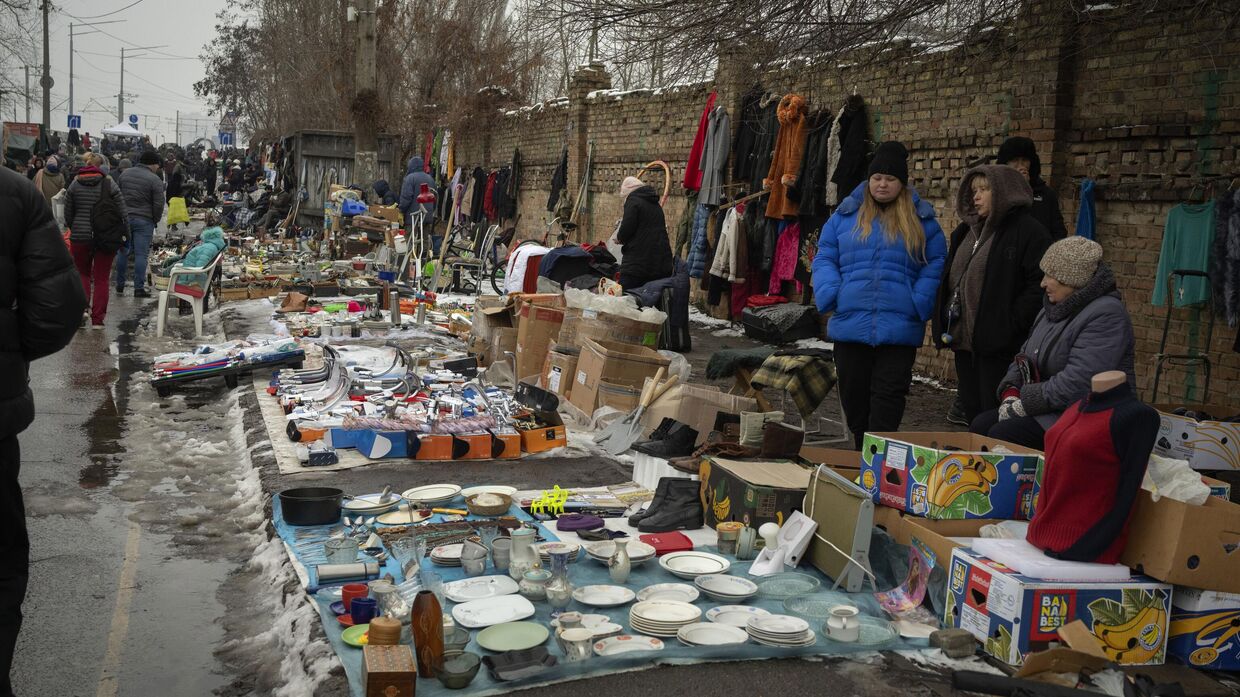 Люди продают вещи на городском блошином рынке в Киеве, покупателей немного