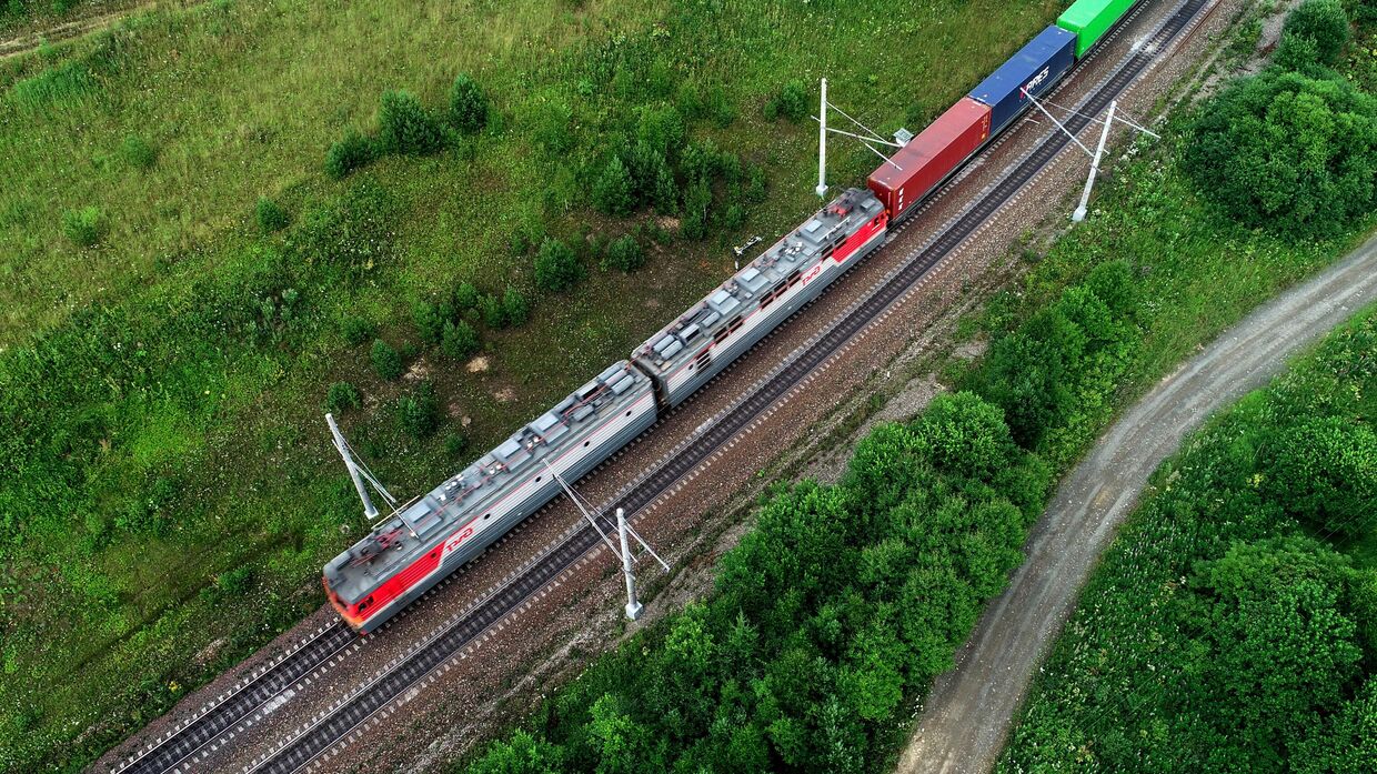 Товарный поезд дальнего следования перевозит контейнеры по Транссибу