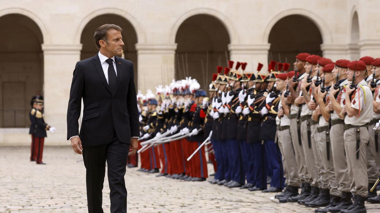 Президент Франции Эммануэль Макрон осматривает почетный караул во время национального чествования покойного генерала французской армии Жана-Луи Жоржелена, бывшего начальника штаба вооруженных сил, 25 августа 2023 г. 