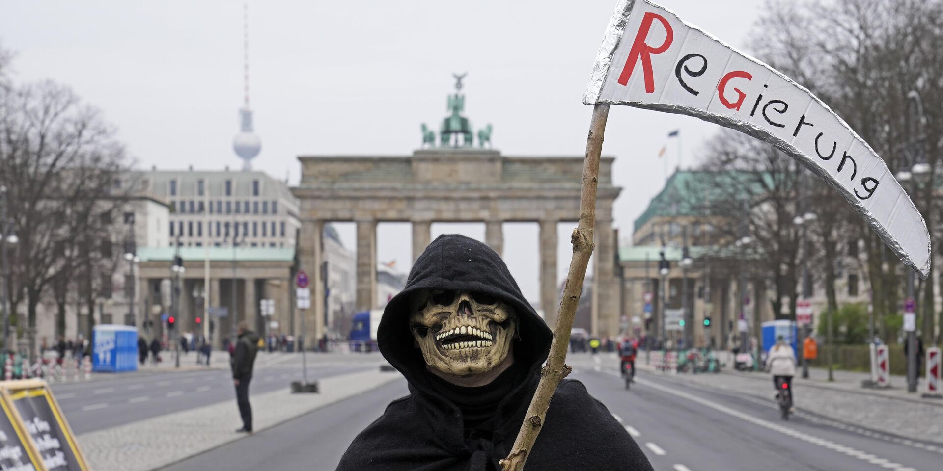 Мужчина, переодетый в смерть, протестует перед Бранденбургскими воротами с косой, на которой надписано Правительство, во время демонстрации фермеров в Берлине - ИноСМИ, 1920, 04.06.2024