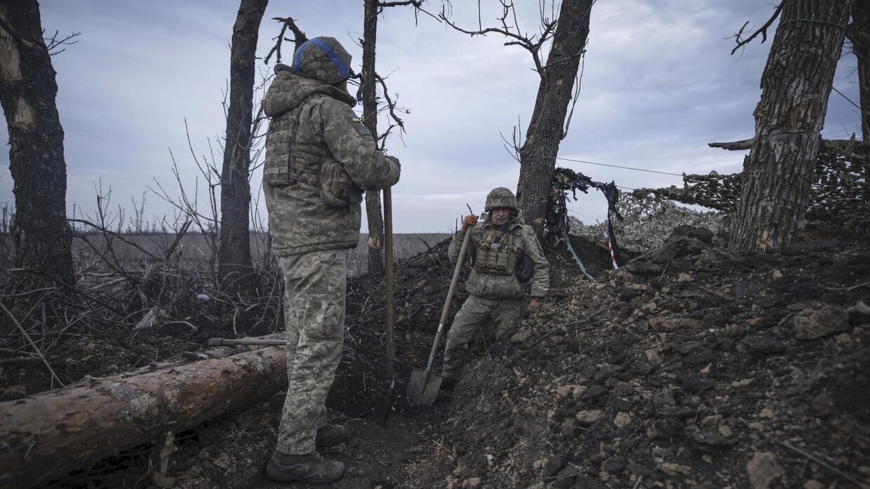 Украинские солдаты роют траншею на линии фронта близ Клещеевки, недалеко от Донецка