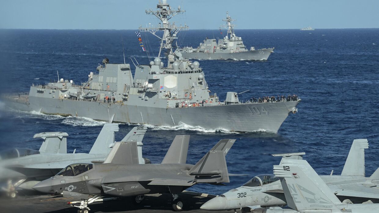 Американские эсминцы класса Арли Берк с управляемыми ракетами USS Sterett (на переднем плане) и USS Rafael Peralta (сзади) видны с палубы авианосца USS Carl Vinson