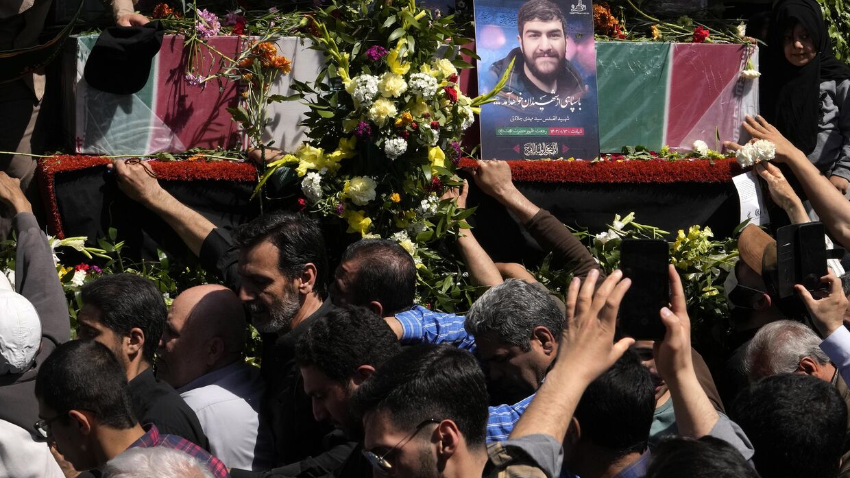 Скорбящие иранцы во время похоронной процессии в Тегеране пытаются прикоснуться к гробам членов Корпуса стражей Исламской революции, погибших в результате авиаудара Израиля по консульству Ирана в Сирии