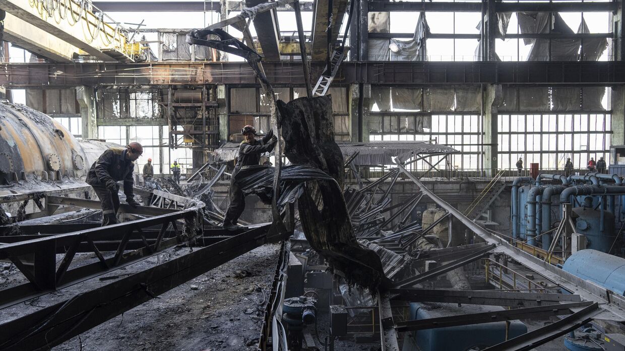 Рабочие разбирают завалы после российского ракетного обстрела электростанции ДТЭК на Украине 2 апреля 2024 года