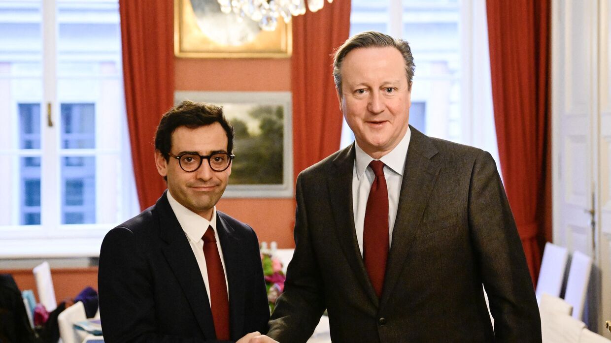 Министр иностранных дел Франции Стефан Сежурн (слева) и министр иностранных дел Великобритании Дэвид Кэмерон пожимают друг другу руки перед двусторонней встречей на полях Мюнхенской конференции по безопасности, 17 февраля, 2024 год.