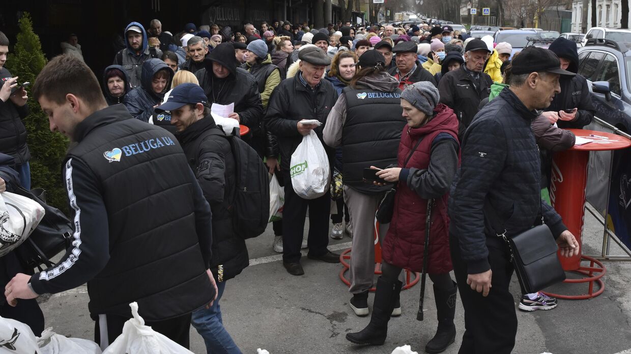 Люди получают гуманитарную помощь в пункте раздачи в Запорожье, Украина 7 апреля 2023 года