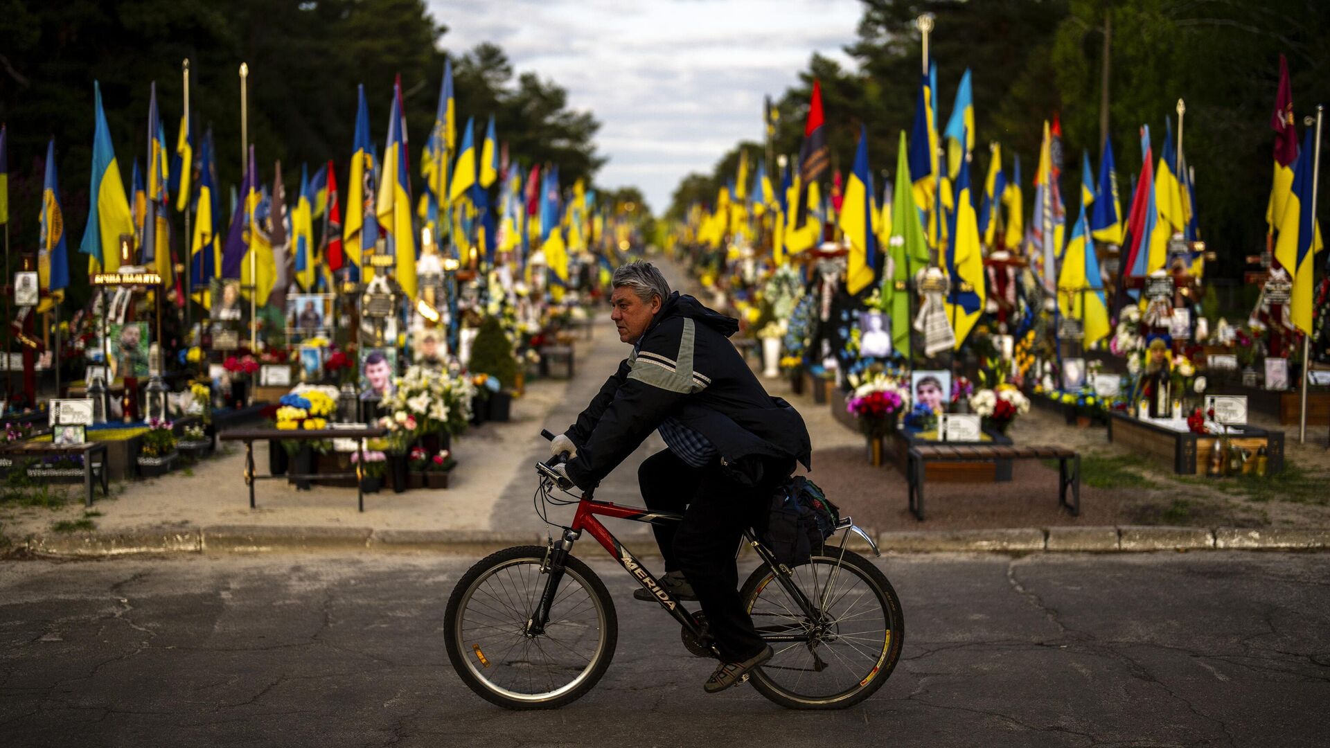 Велосипедист проезжает мимо могил украинских солдат, погибших во время боевых действий, на Лесном кладбище в Киеве - ИноСМИ, 1920, 25.04.2024