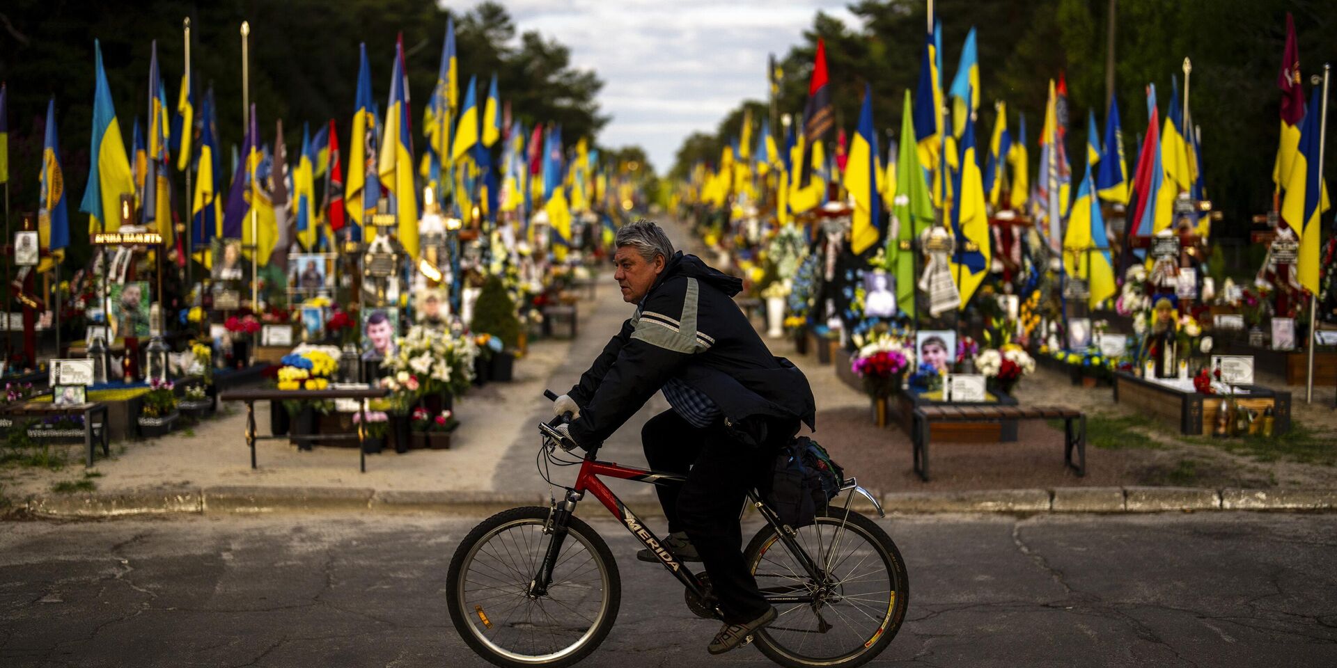 Велосипедист проезжает мимо могил украинских солдат, погибших во время боевых действий, на Лесном кладбище в Киеве - ИноСМИ, 1920, 25.04.2024