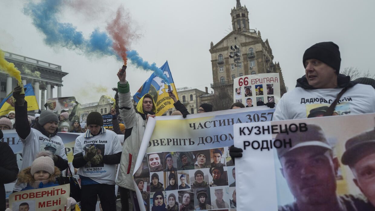 Украинцы держат в руках фотографии пропавших солдат во время демонстрации в центре Киева. 14 января 2023 года.