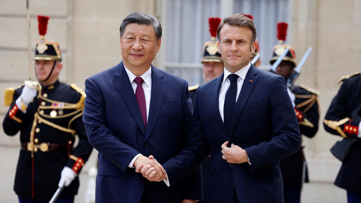 Президент Франции Эммануэль Макрон приветствует председателя Китая Си Цзиньпина в Елисейском дворце во время его официального государственного визита в Париж 6 мая 2024 года. 